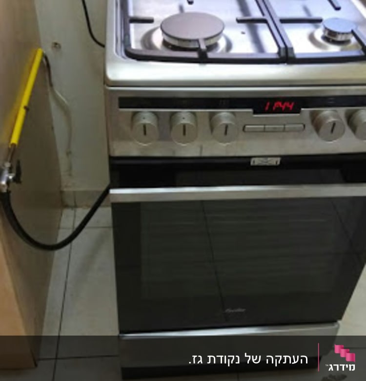 תנור גז עם כיריים מחובר לצינור גז צהוב